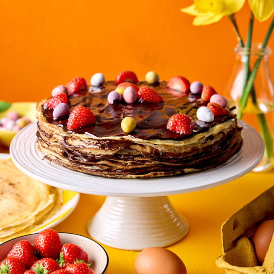 Easter pancake layered cake with chocolate eggs and strawberries