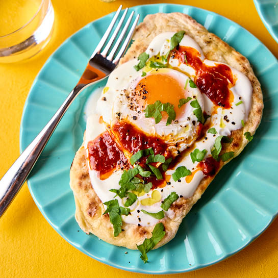 Turkish eggs on a flatbread with harissa and herbs